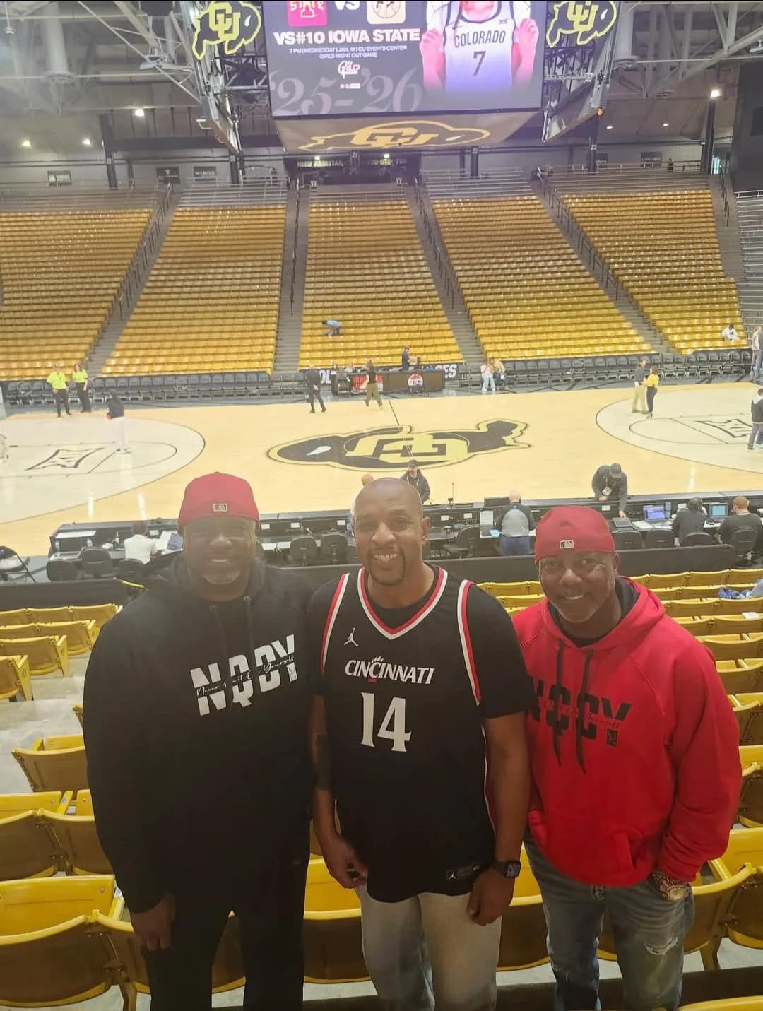 Three men in NQOY at a basketball arena