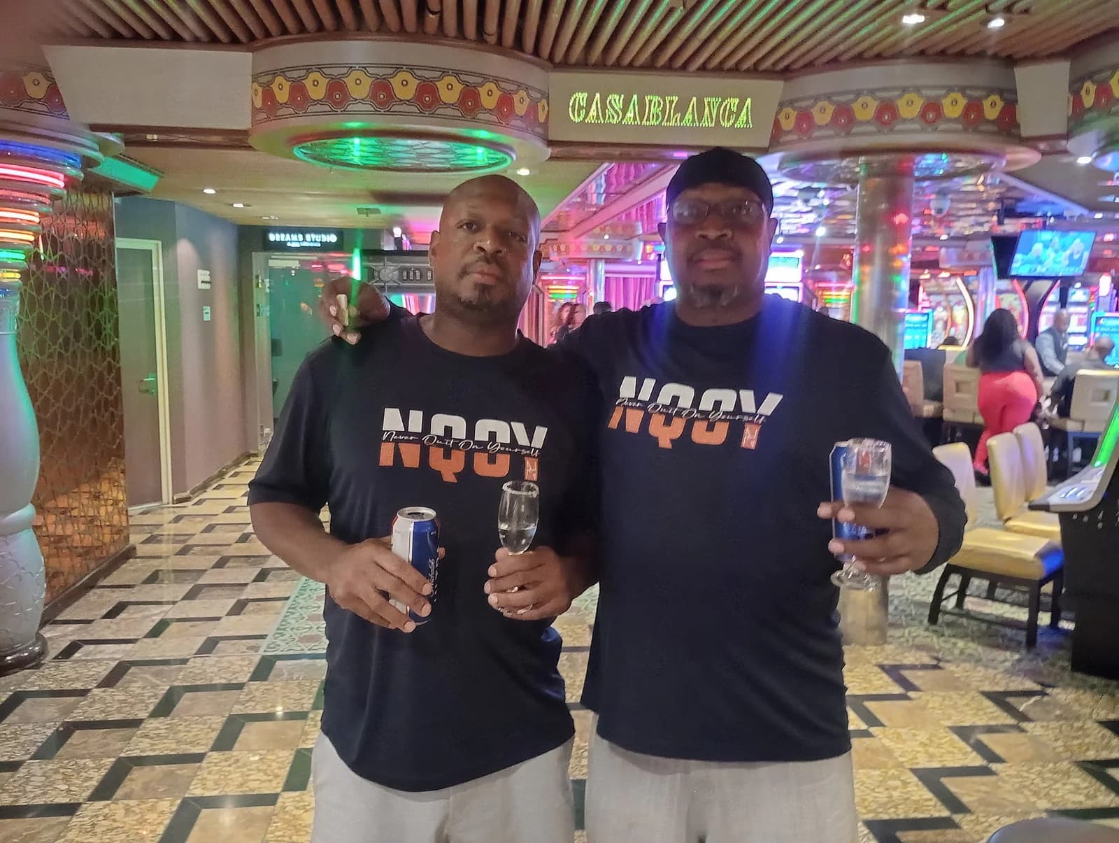 Two men in NQOY tees on a night out