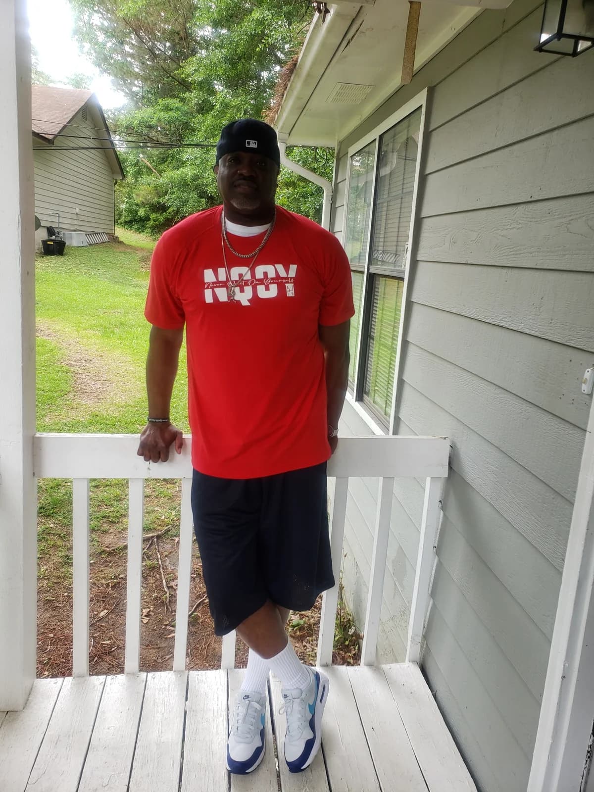 A man in a red NQOY tee