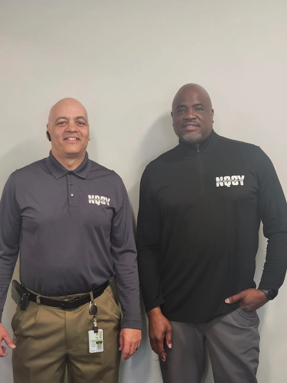 Two men in NQOY polos at work